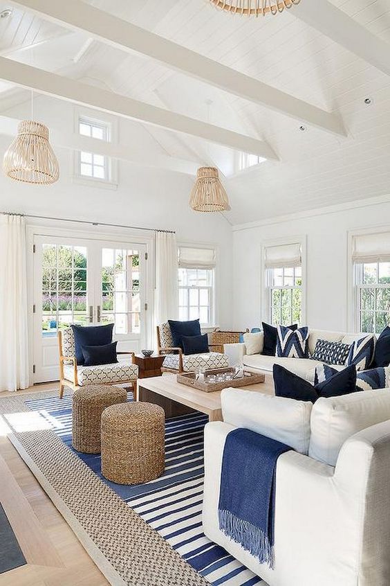 a preppy coastal living room with rattan lampshades, jute ottomans, stripes and traditional furniture