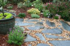 a relaxed and all-natural garden path with pebbles and rough dark stones of various shapes and looks