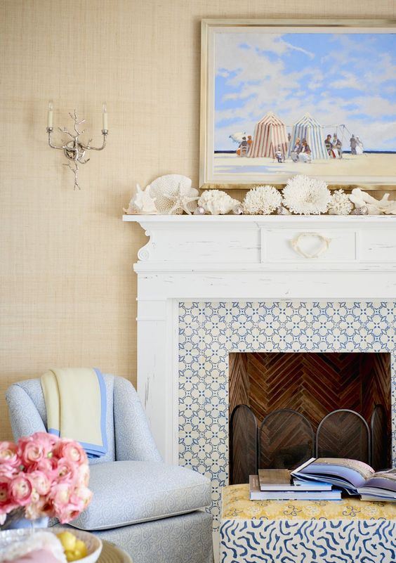 a seaside mantel with corals, starfish, seashells, driftwood and a bright beachy artwork over the mantel