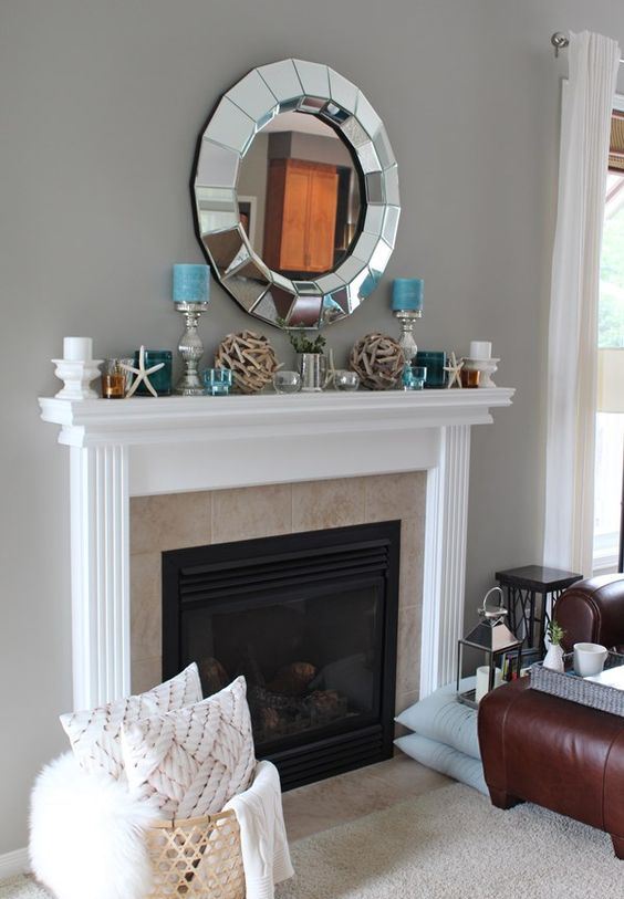 a simple and stylish beach mantel with driftwood balls, blue and white candles, glass candleholders and starfish