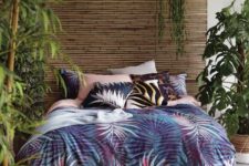 a single bamboo wall, a bamboo rug, lots of potted greenery and bright tropical bedding create an ambience