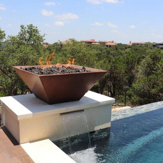 a square aged metal fire bowl place right on the fountain allows you to enjoy two elements in one and makes your backyard spectacular