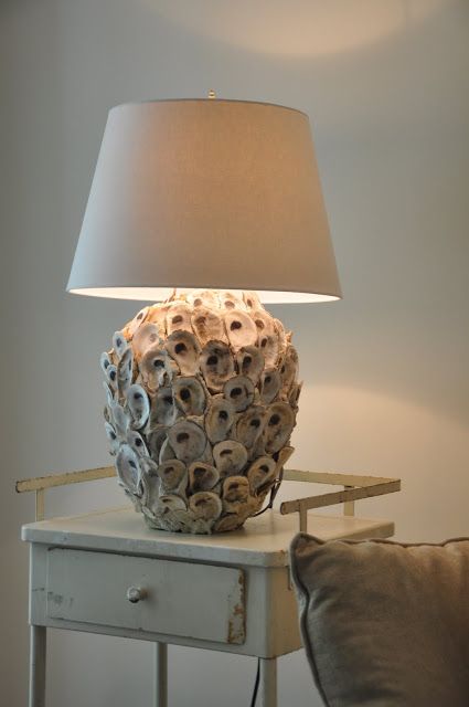 a table lamp with a base covered with seashells and a plain lampshade is a lovely idea for a seaside or beachy space