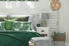 a tropical Roman shade and bedding, a basket and a potted plant brign a tropical feel to this neutral sleeping space