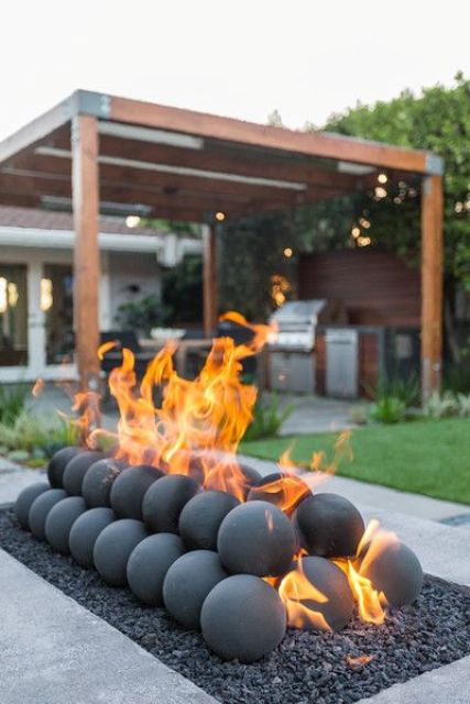 a unique fire bowl as an installation of pebbles, stone balls is a lovely idea for a contemporary outdoor space