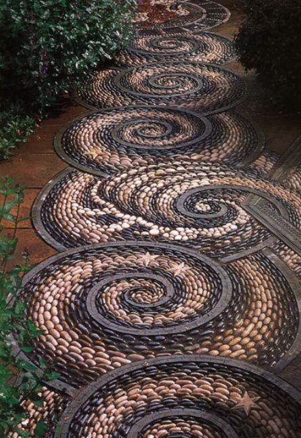 a very bold pebble garden pathway with black and white swirl patterns and even stars will make a statement