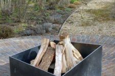 a very laconic and simple asymmetrical metal fire pit is a great idea for many modern backyards