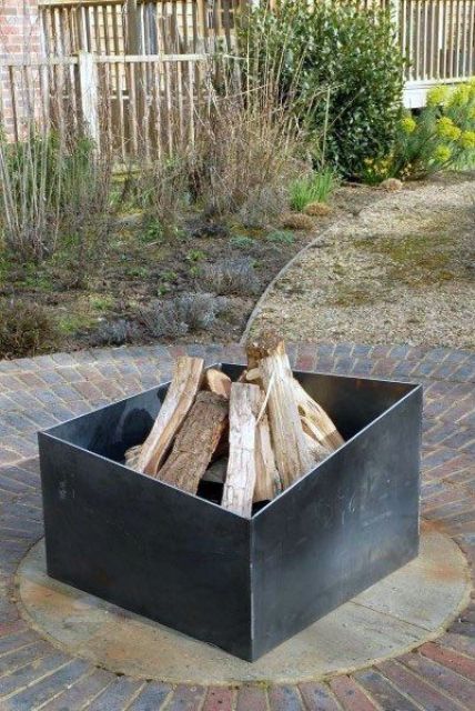 a very laconic and simple asymmetrical metal fire pit is a great idea for many modern backyards