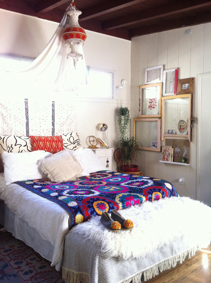 Dreamy canopy, ethnic patterns, and mixed art in mismatched frames make this bedroom looks quite chic.