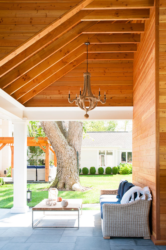 a small yet cozy rustic patio with wicker furniture and simple textiles and a low coffee table  (DHMurray Architecture)