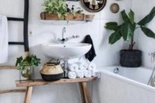 a boho bathroom with decorative baskets, a crochet rug, baskets for storage and potted plants