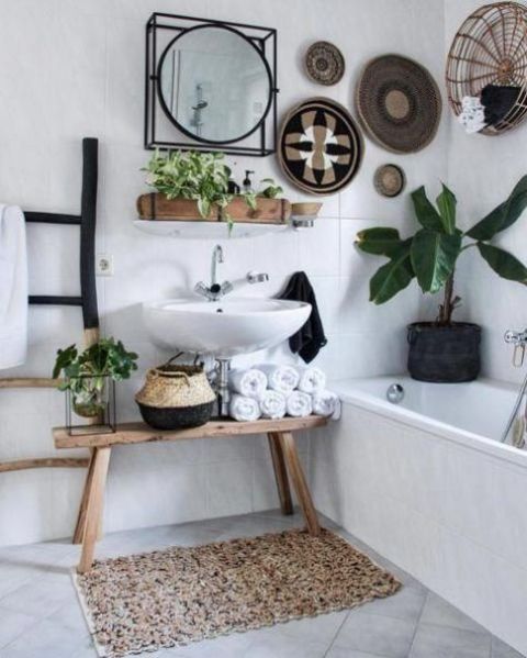 a boho bathroom with decorative baskets, a crochet rug, baskets for storage and potted plants