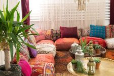 a boho living space with floor cushions and pillows instead of a sofa, rugs and pendant lamps