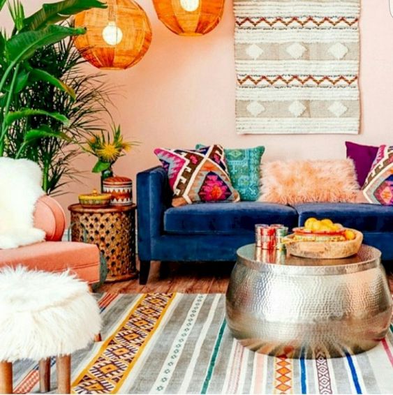 a bright Moroccan living room with colorful textiles and patterns, a hammered coffee table and lamps