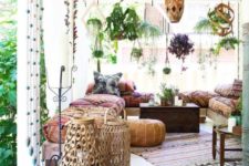 a bright boho patio with wooden and metal lanterns, rattan lamps on the floor, colorful and printed textiles, rugs and pillows