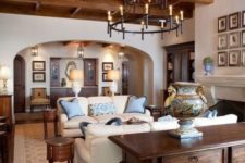 a chic and cozy rustic living room with rich stained furniture, a wooden ceiling and neutral sofas plus a fireplace