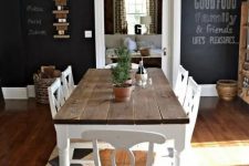 a chic farmhouse dining space with a rustic wooden dining set, a chalkboard wall and a vintage chandelier