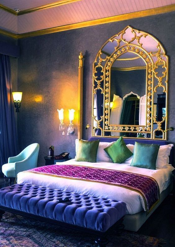 a colorful Moroccan bedroom in purple, blue and emerald, with gold touches and a framed mirror is a fersh take on Eastern bedrooms