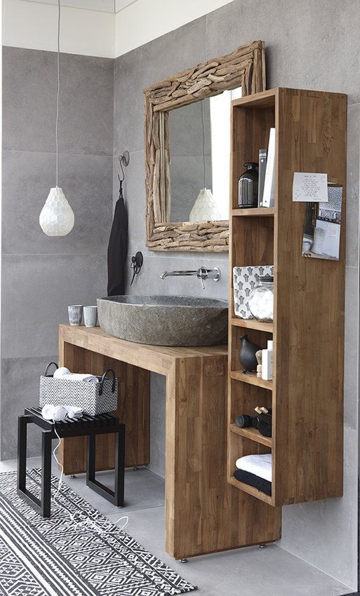 a contemporary meets rustic bathroom with a concrete sink, a wood clad mirror and wooden furniture