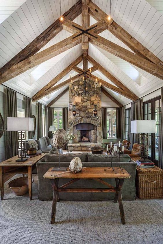 a cottage living room with a stone clad fireplace, wooden beams, wooden furniture and baskets