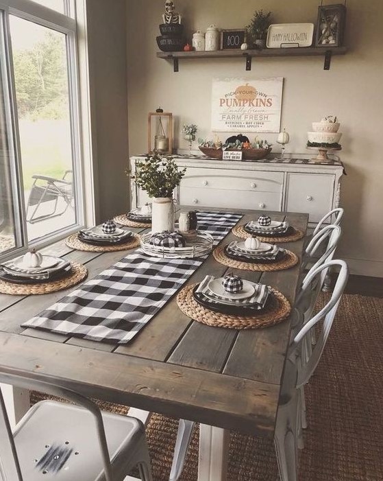 a cozy traditional farmhouse dining room with checked textiles, a wooden table, metal chairs and a buffet