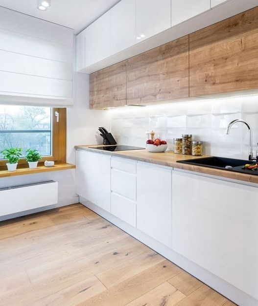 a minimalist Scandi kitchen with wooden upper cabinets, sleek white lower ones, a windowsill shelf and built-in lights