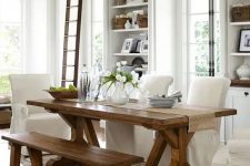 a neutral modern farmhouse dining room with a wooden dining set, some white chairs and built-in storage units