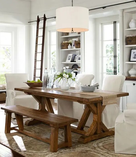 a neutral modern farmhouse dining room with a wooden dining set, some white chairs and built in storage units