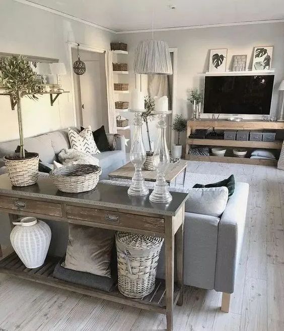 a neutral rustic living space with a wooden console, TV unit and a coffee table plus some baskets for storage