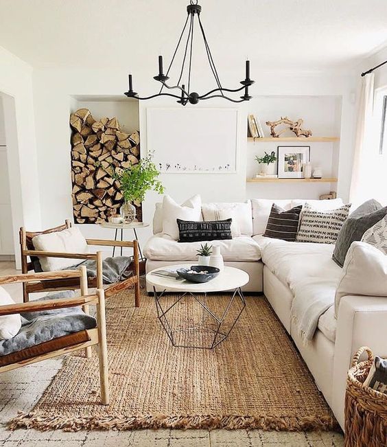 a rustic living room with a jute rug, a firewood storage, comfy furniture and a basket with firewood