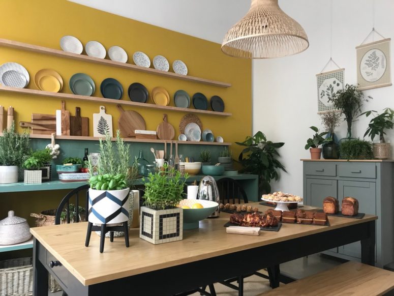 a stylish kitchen with mustard walls, green tiles on the backsplash and floating shelves