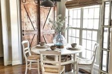 a vintage farmhouse dining nook with wooden doors, a white dining set, wicker shades and a metal lamp