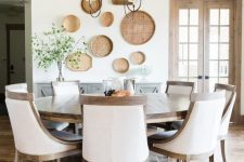 a vintage farmhouse dining room done in neutrals and with a large wooden round table