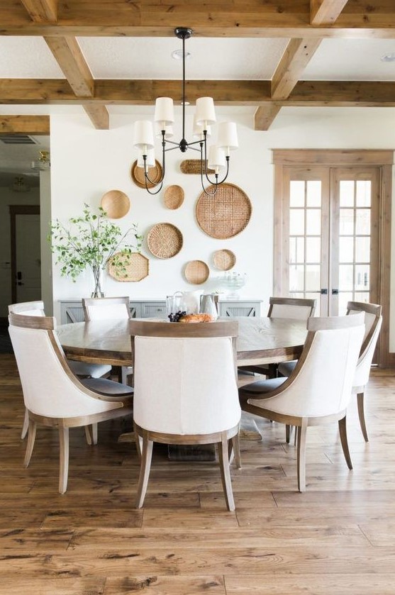 a vintage farmhouse dining room done in neutrals and with a large wooden round table