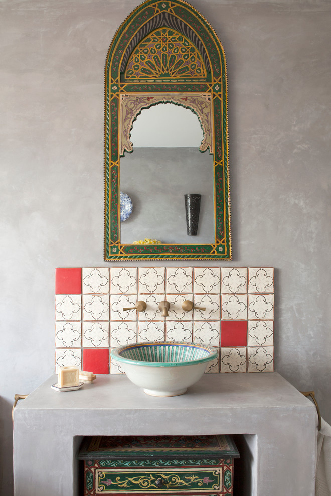 a Moroccan sink space with an oranted mirror, a red and white tile backsplash and a painted bowl sink  (The Brighton Bathroom Company)