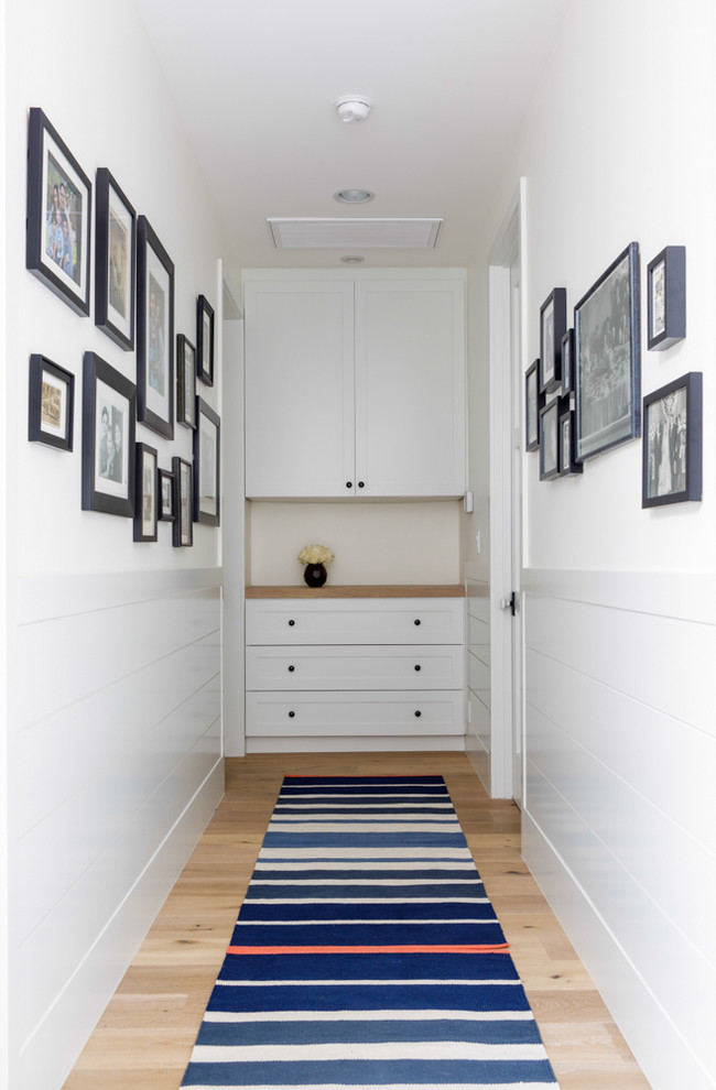 A built-in cabinet could have enough space for a linen storage. A gallery wall is as trendy addition to a hallway as to any other room.