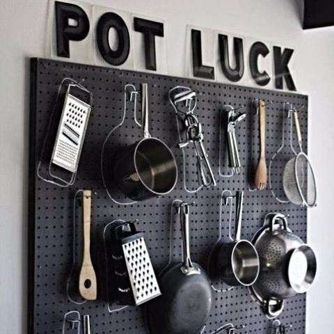 a black pegboard with lots of hangers and hooks is great for hanging pots and pans where you want