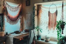 a boho chic home office with fringe and macrame hangings, potted plants, faux fur, a beaded chandelier and a macrame runner on the desk