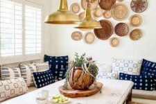 a bright boho dining space with an arrangement of decorative plates, pendant lamps, colorful printed pillows