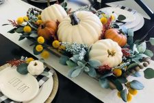 a bright fall centerpiece of a wooden bowl, greenery, craspedia, neutral pumpkins can be easily arranged