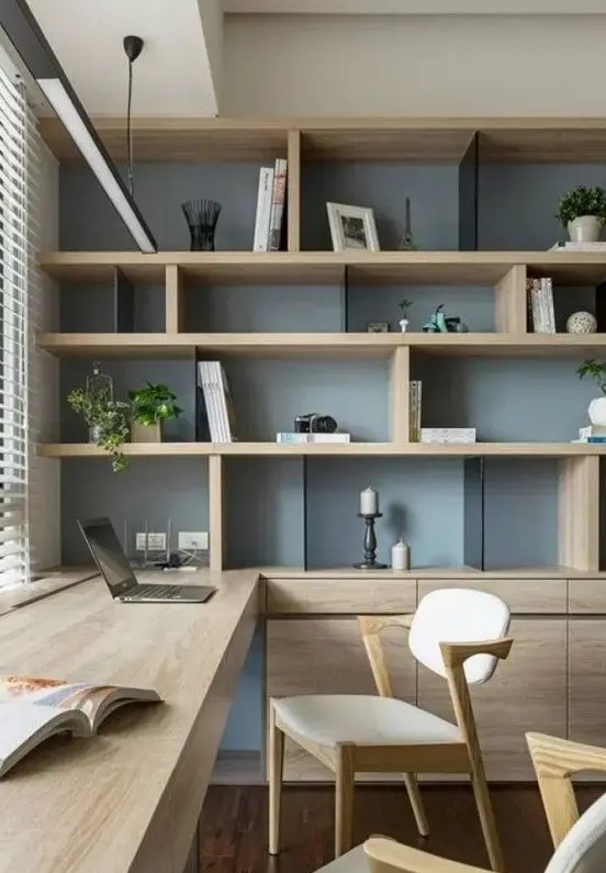 a chic contemporary home office with a storage unit that takes a whole wall, with open and closed storage compartments, a built-in desk and chic modern chairs