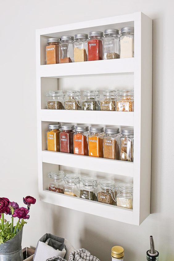 a compact open shelf with spices in jars is a cool spice rack idea that will be useful in any kitchen