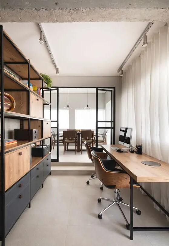 a contemporary industrial home office with a large storage unit of wood and metal, a stylish shared desk and leather and plywood chairs