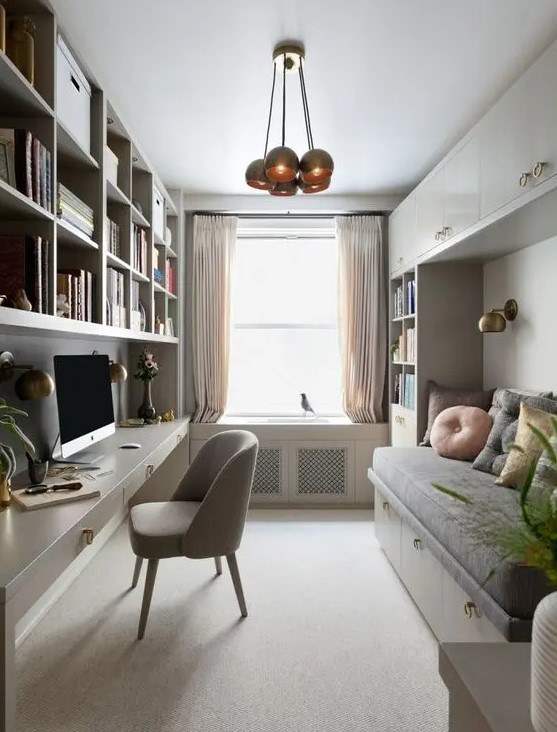 a cozy neutral home office with a large shelving unit and a built-in desk, a comfy grey chair, a built-in daybed and storage cabinets