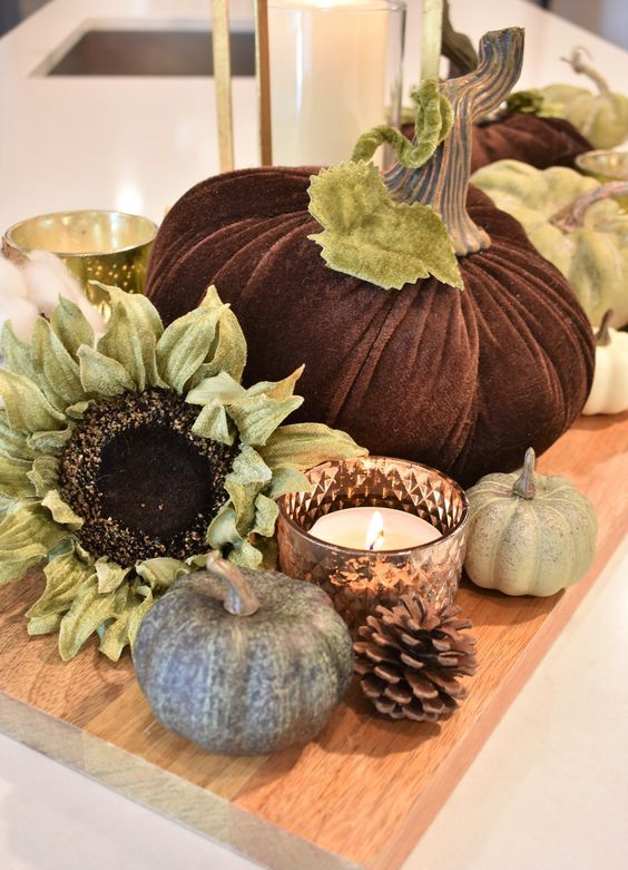 une planche à découper avec de fausses citrouilles, des fleurs, des bougies et des pommes de pin pour un décor rustique durable une planche à découper avec de fausses citrouilles, des fleurs, des bougies et des pommes de pin pour un décor rustique durable