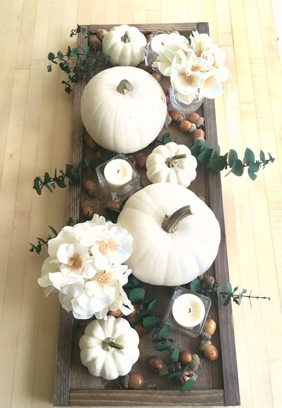 un plateau en bois teinté foncé, des citrouilles blanches, des fleurs, des bougies et des glandes pour une jolie pièce maîtresse d'automne un plateau en bois teinté foncé, des citrouilles blanches, des fleurs, des bougies et des glandes pour une jolie pièce maîtresse d'automne