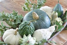 a dough bowl with pumpkins and gourds and foliage is a cool fall all-neutral centerpiece