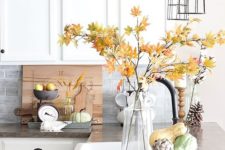 a fall leaf arrangement in a clear vase, faux veggies, pinecones and wheat in vases for natural fall decor