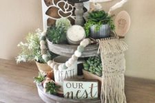 a fall rustic and boho wooden tand with succulents, greenery, a sign, a candle and a macrame decoration