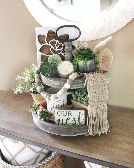 un tand en bois rustique et boho d'automne avec des plantes succulentes, de la verdure, une enseigne, une bougie et une décoration en macramé un tand en bois rustique et boho d'automne avec des plantes succulentes, de la verdure, une enseigne, une bougie et une décoration en macramé